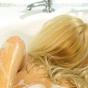 Blonde young lady soaps up her body