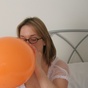 Wench in stockings blowing up balloons