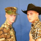 A cowboy and a soldier posing naked in front of mirrors