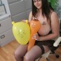 Board busty girl at work playing with balloons