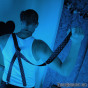 Brooding bad-boy in suspenders under blue light.