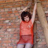 Hot brown-haired girl in sexy lingerie tied up to scaffolding